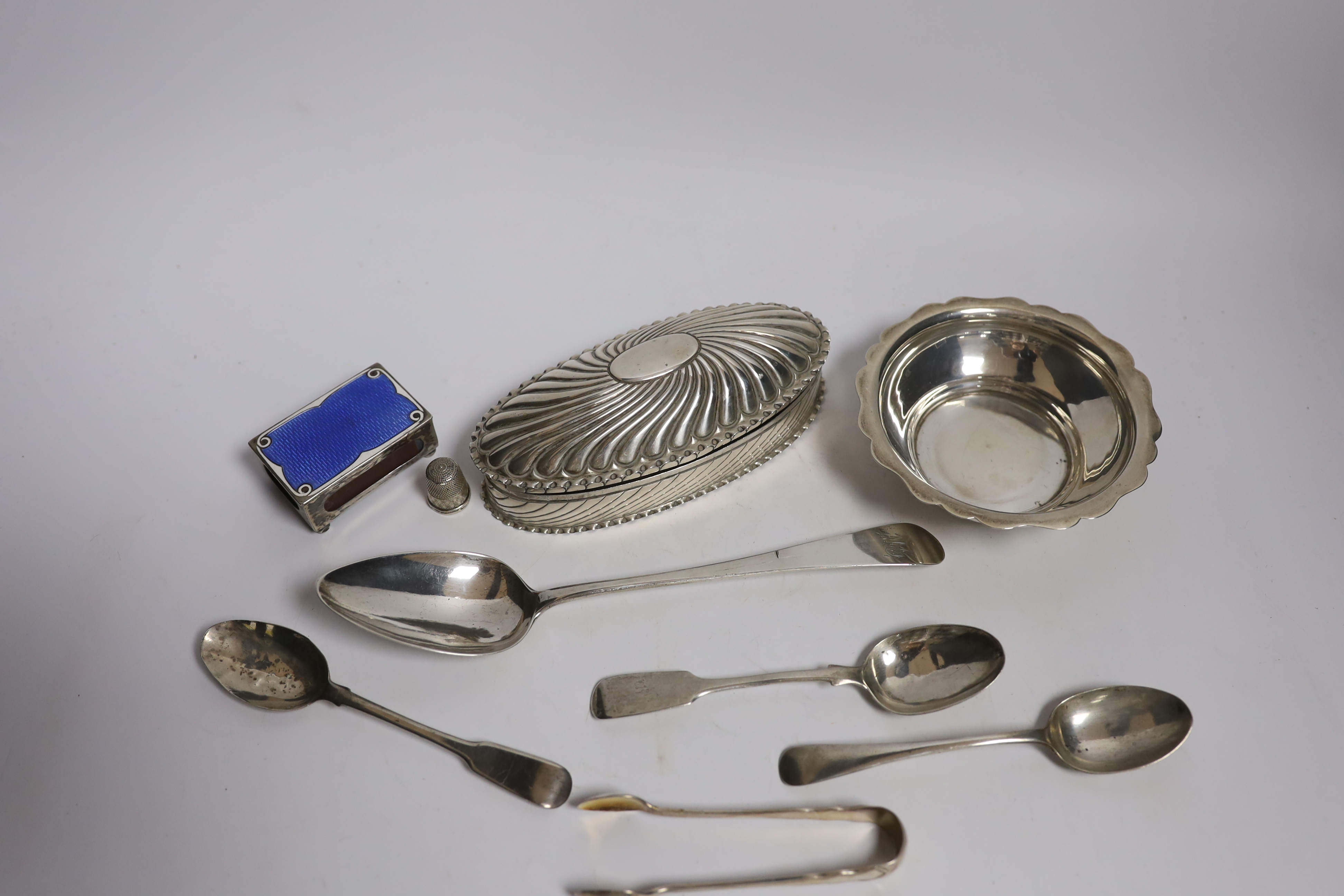 A late Victorian repousse silver oval trinket box by Horton & Allday, Birmingham, 1890, 15.2cm, together with five items of silver flatware, a silver bowl, silver and enamel matchbox sleeve and a sterling thimble.